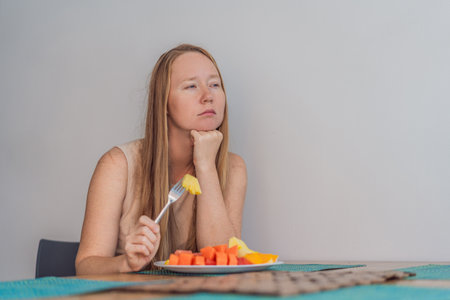 Woman enjoying a peaceful breakfast at the table in a bright home interior, starting her morning with calm energy. Healthy lifestyle, morning routine and wellbeing concept, representing self-care, balance and everyday home livingの写真素材