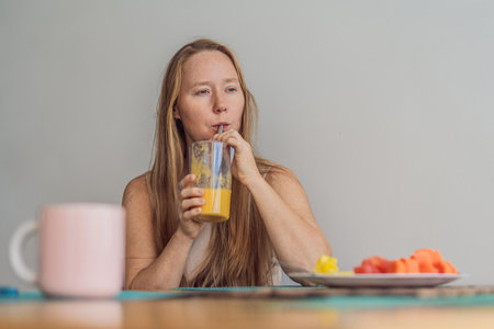 Woman enjoying a peaceful breakfast at the table in a bright home interior, starting her morning with calm energy. Healthy lifestyle, morning routine and wellbeing concept, representing self-care, balance and everyday home livingの写真素材