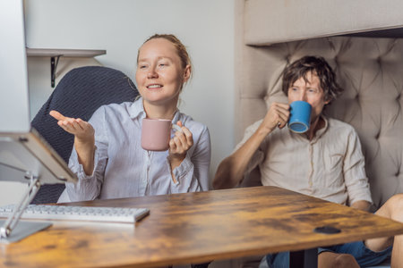 Man and woman working together in their home office, discussing tasks and collaborating on a project. Modern remote work, teamwork and productivity concept, representing communication, focus and contemporary professional lifestyleの写真素材