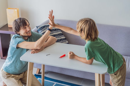 Father and his son assembling a table together in the living room at home. Meaningful family moment...