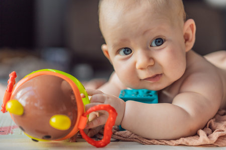 Little baby playing with toys on a soft baby play mat at home. Early childhood development, sensory...