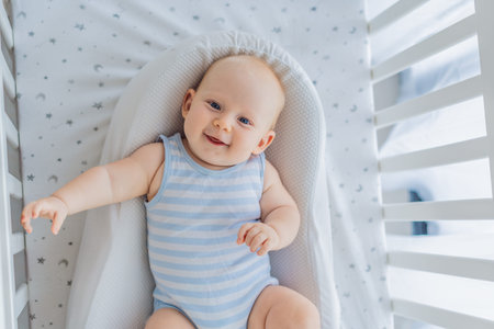 Baby lying peacefully in a cozy cocoon nest inside a crib, feeling safe and calm at home. Soft light...