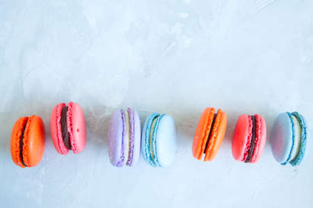 Line of colorful macarons on a white stone background. Close up and copy space.の写真素材