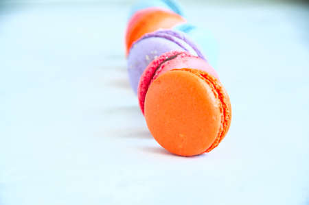 Line of colorful macarons on a white stone background. Close up and copy space.の写真素材