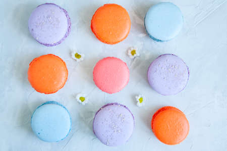 Three lines of colorful macarons on a white stone background. Close up and copy space.の写真素材