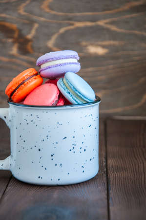 Colorful macarons in a white jar on a wooden background. Close up and copy space.の写真素材