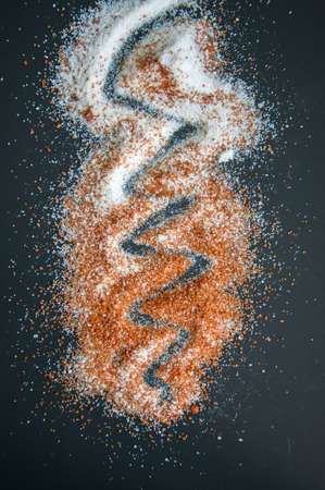 Sifting brown and white sugar on a black backgroundの写真素材