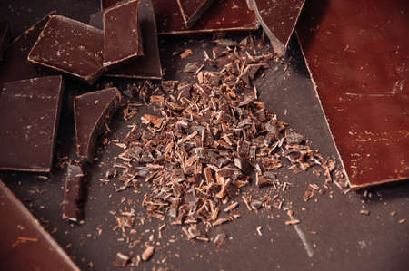 Whole and pieces of dark chocolate bars on a darkbackground  at monochrome setting. Toned.の写真素材