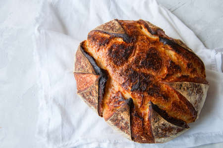 Close up of freshly baked sourdough bread on a white stone background. Top view and copy space.の写真素材