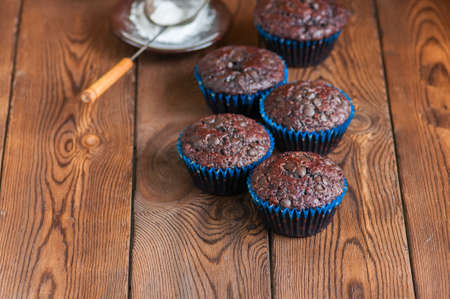 Freshly baked double chocolate muffins on a wooden background with copy space.の写真素材