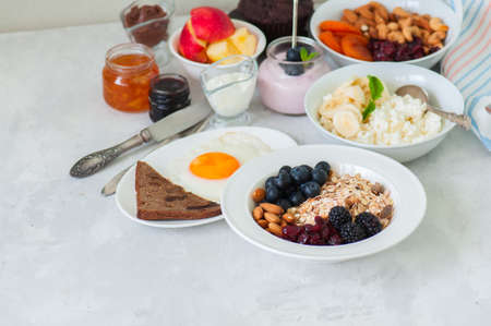 Healthy breakfast concept. Homemade granola (muesli) with blackberry, dry cranberry, blueberry,...