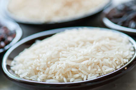 Basmati rice in a plate on a white stone background. Toned.の写真素材