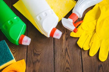 Cleaning concept. Sprays and rubber gloves on a wooden backgroundの写真素材