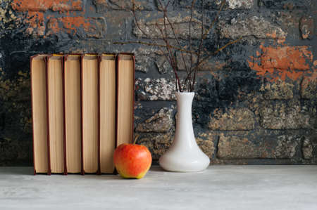 Old books, apple and brunches in vase. Autumn mood, reading conceptsの写真素材