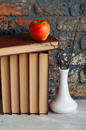 Old books, apple and brunches in vase. Autumn mood, reading conceptsの写真素材