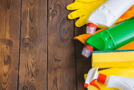 Cleaning concept. Sprays and rubber gloves on a wooden backgroundの写真素材