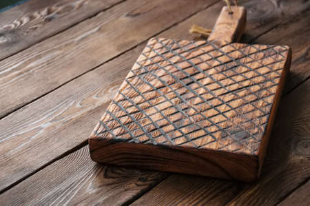 Rustic cutting empty board over kitchen table.の写真素材