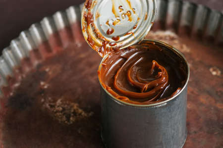 Caramel condensed milk in can on a brown background.の写真素材
