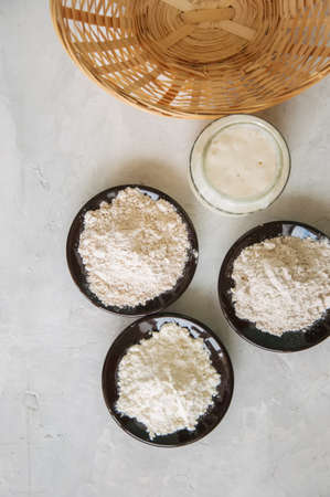 Sourdough in a jar, mix of flours, basket for proof on a gray stone background. Baking concept.の写真素材
