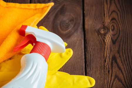 Cleaning concept. Sprays and rubber gloves on a wooden backgroundの写真素材