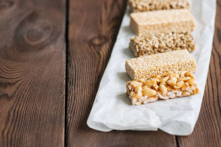 Snacks  - mix of energy bars with peanut, sesame and sunflower seeds on a wooden backgroundの写真素材