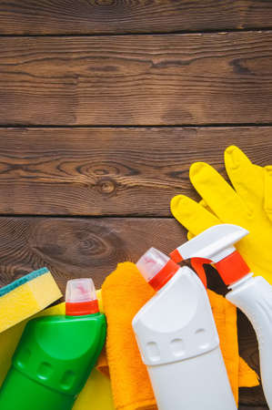 Cleaning concept. Sprays and rubber gloves on a wooden backgroundの写真素材