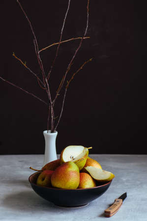 Ripe pears in a plate on a white stone background. Toned.の写真素材