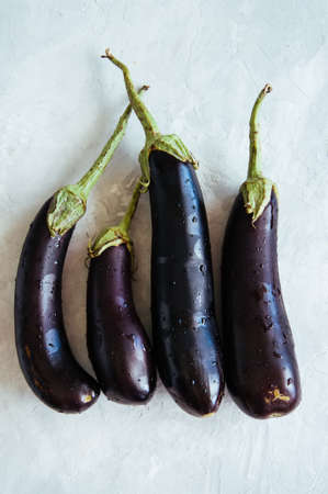 Four eggplants on a white stone background. Top view.の写真素材