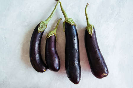 Four eggplants on a white stone background. Top view.の写真素材