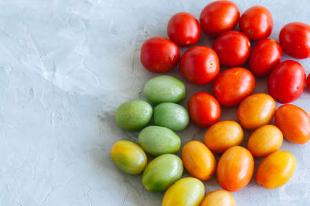 Bright colorful tomatoes cherry on a white stone background. Overhead view and copy space.の写真素材