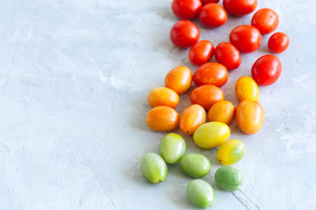 Bright colorful tomatoes cherry on a white stone background. Overhead view and copy space.の写真素材