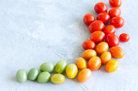 Bright colorful tomatoes cherry on a white stone background. Overhead view and copy space.の写真素材