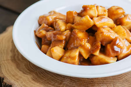 Slices of apple with caramel sauce on a wooden board. Wooden background, close up .の写真素材