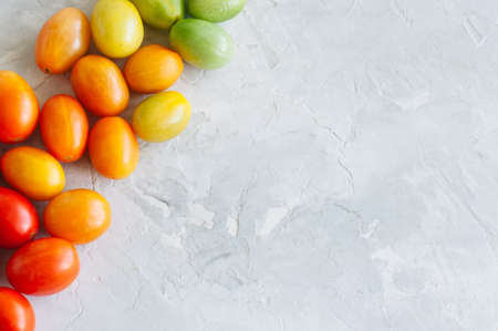 Bright colorful tomatoes cherry on a white stone background. Overhead view and copy space.の写真素材