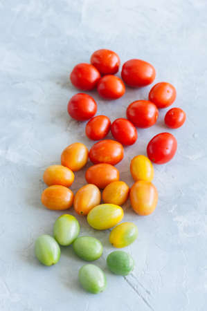 Bright colorful tomatoes cherry on a white stone background. Overhead view and copy space.の写真素材