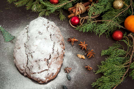 Chocolate Stollen sprinkled with powdered sugar. Traditional German Festive Baking. Toned.の写真素材