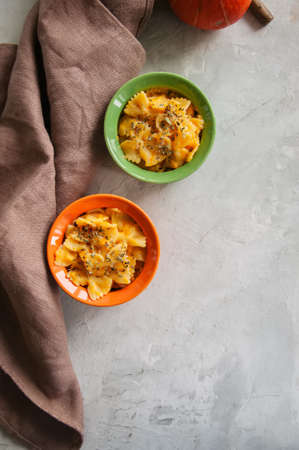 Pumpkin creamy mac and cheese baked pasta over white stone background. Comfort food.の写真素材