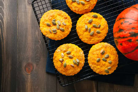 Pumpkin scones on a wire rack over wooden background.の写真素材