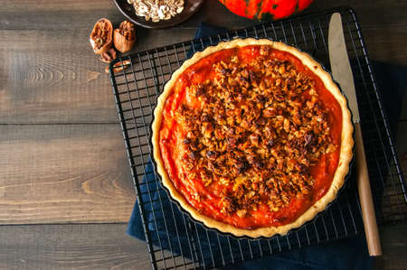 Pumpkin pie with oat pecan crust on a wooden backgroundの写真素材
