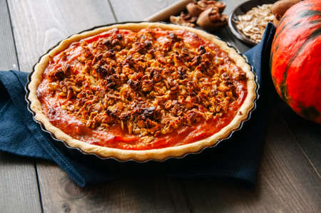 Pumpkin pie with oat pecan crust on a wooden backgroundの写真素材