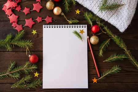 White empty notepad paper with christmas decoration on a wooden background. Flat lay.の写真素材
