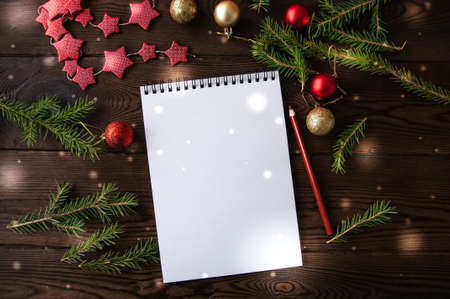 White empty notepad paper with christmas decoration on a wooden background. Flat lay.の写真素材