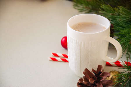 Christmas background with a cup of latte, fir tree branches, cones and balls. Gray backdrop. Close up.の写真素材