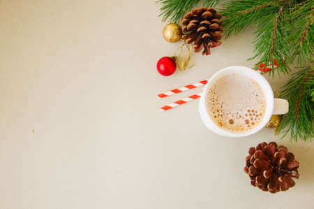 Christmas background with a cup of latte, fir tree branches, cones and balls. Gray backdrop. Top view.の写真素材