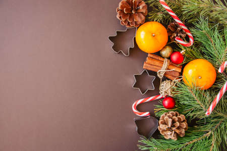 Christmas decoration. Background with fir tree branches, oranges, candy canes and cookie cutters.の写真素材