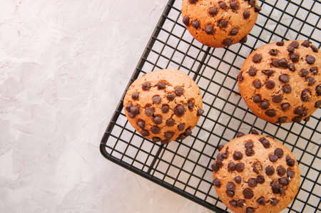 Chocolate chip cookies on a wire rack on white stone backgroundの写真素材