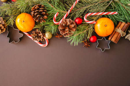 Christmas decoration. Background with fir tree branches, oranges, candy canes and cookie cutters.の写真素材