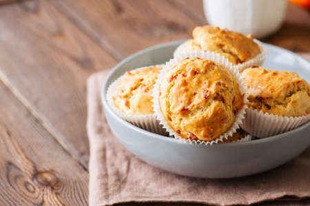 Homemade muffins with bacon and cheese in a gray plate. Healthy snack or breakfast meal. Wooden background.の写真素材