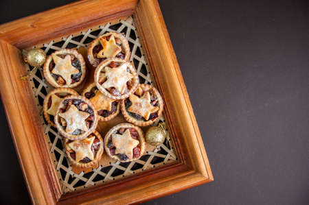 Mince pies in a wooden frame board. Traditional Christmas baking.の写真素材
