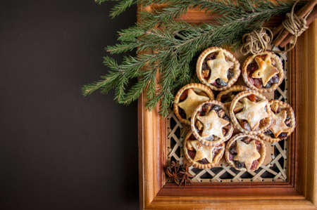 Mince pies in a wooden frame board. Traditional Christmas baking.の写真素材